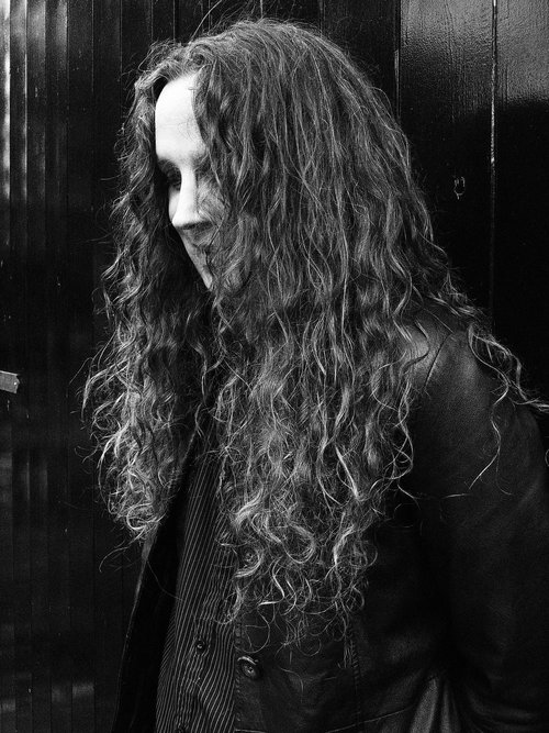 Black and white photo of RJ Baker, a white man with long wavy hair.